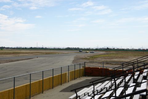 1995 Ford Taurus - Cars race on a track with spectator seating visible in the foreground.