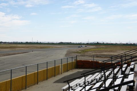 1995 Ford Taurus - A race track scene with several cars on the course, viewed from the spectator stands.