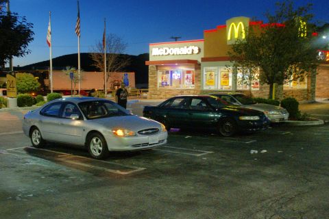 1995 Ford Taurus - A silver 1995 Ford Taurus is parked in front of a McDonald's, with other vehicles nearby.