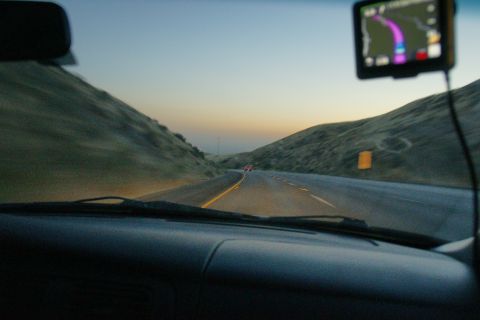 1995 Ford Taurus - Driving on a highway at dusk, with a GPS guiding the way through rolling hills.