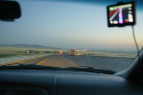 1995 Ford Taurus - View from inside a vehicle traveling on a highway as dusk settles, with distant lights and mountains visible.
