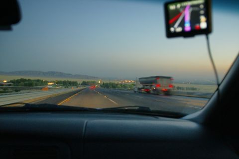 1995 Ford Taurus - Driving on a highway at dusk, with a truck in the distance and a GPS screen visible.