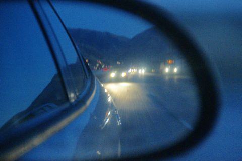 1995 Ford Taurus - View from a car's side mirror shows traffic on a highway as daylight fades.