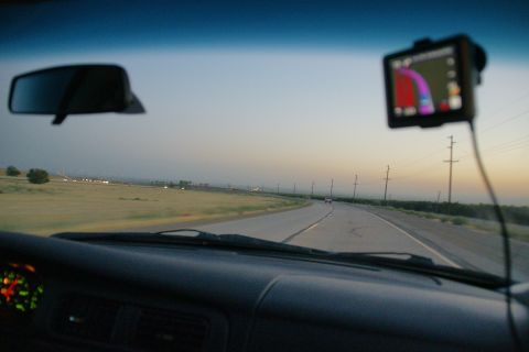 1995 Ford Taurus - Driving down a highway as the sun sets, with a GPS guiding the way.
