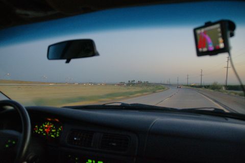 1995 Ford Taurus - View from inside a vehicle at dusk, with a GPS mounted on the windshield and the speedometer illuminated.