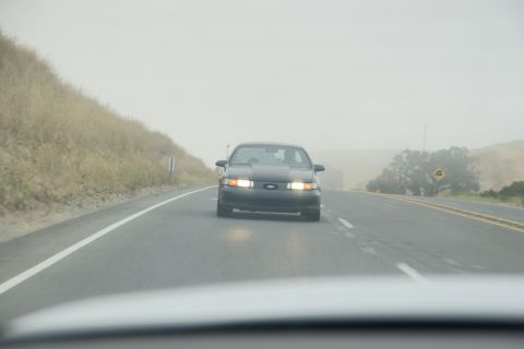 1995 Ford Taurus - Front view of a 1995 Ford Taurus on a foggy highway.