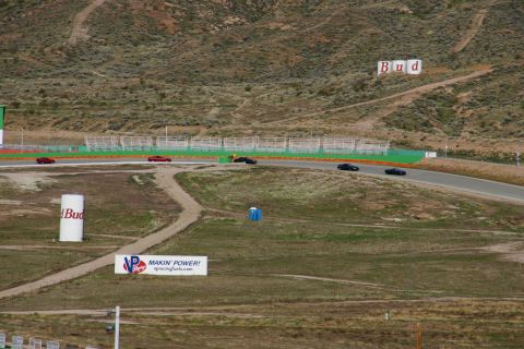 1995 Ford Taurus - Cars race on a track with advertising signs and a portable toilet in the background.