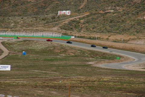 1995 Ford Taurus - Multiple cars are driving on a race track, with a large Budweiser sign visible on the hillside.