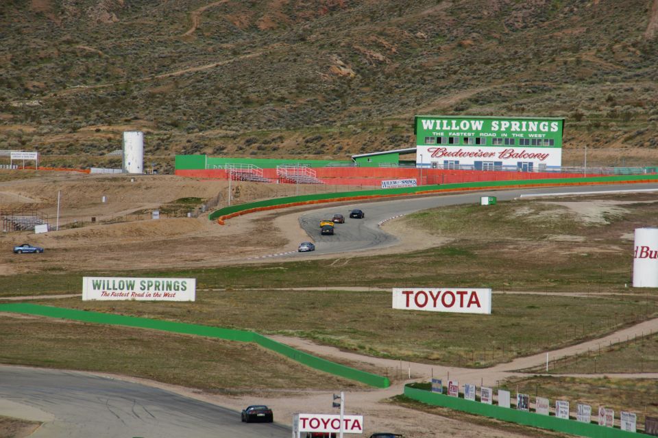 Race cars on a track with Willow Springs signage