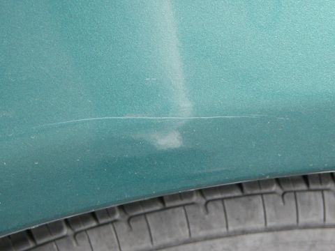 1996 Mercury Sable - A view over the rear driver side wheel well after an apparent "keying" by antisocial elements.