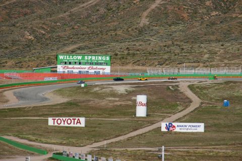1995 Ford Taurus - Willow Springs International Raceway hosts a race with several cars on the track, including a dark sedan and a yellow sports car.