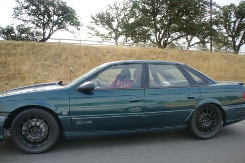1995 Ford Taurus - Side view of a green 1995 Ford Taurus sedan on the road.