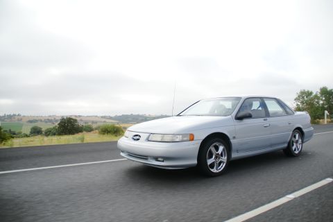 1995 Ford Taurus - Silver 1995 Ford Taurus sedan on a highway under an overcast sky.