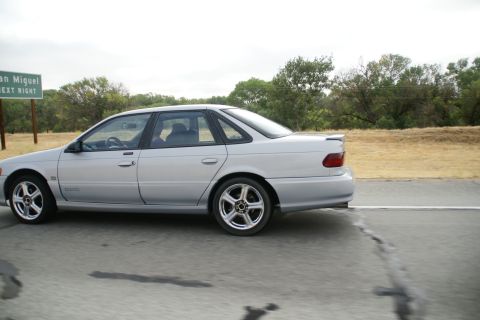 1995 Ford Taurus - Silver 1995 Ford Taurus sedan captured in motion on a highway.