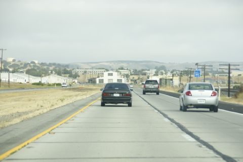 1995 Ford Taurus - Highway scene with multiple vehicles driving under an overcast sky.