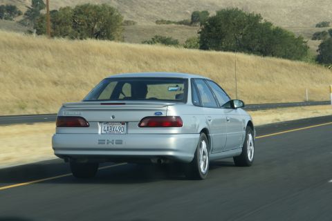 1995 Ford Taurus - A silver 1995 Ford Taurus SHO is seen from behind while driving on a highway.