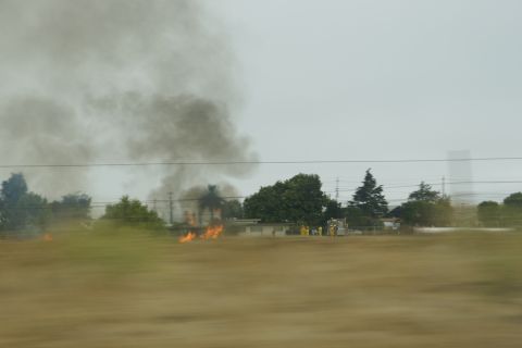 1995 Ford Taurus - Firefighters respond to a fire, with thick smoke billowing into the sky.