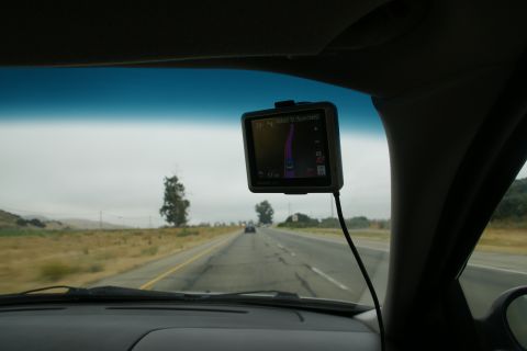 1995 Ford Taurus - GPS navigation device mounted on windshield while driving on a highway.