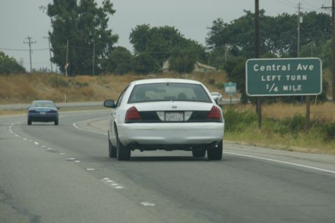 1995 Ford Taurus - White sedan driving on highway near Central Ave exit, with another car ahead.