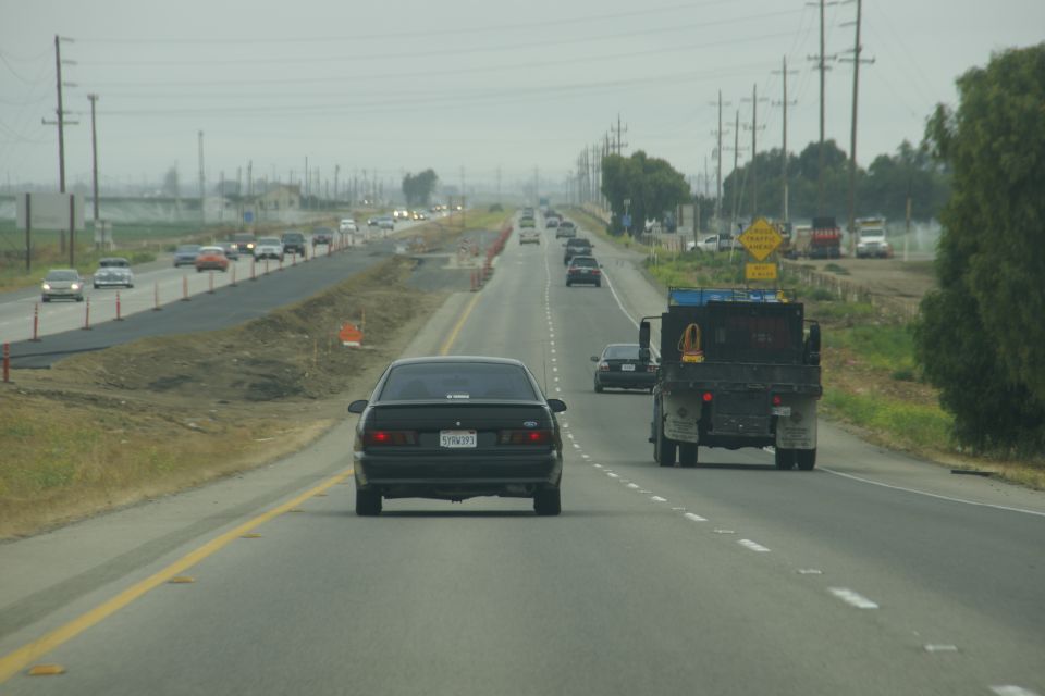 Black 1995 Ford Taurus rear view on highway