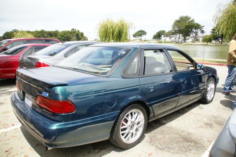 1995 Ford Taurus - Rear quarter view of a 1995 Ford Taurus sedan parked outdoors near a body of water.
