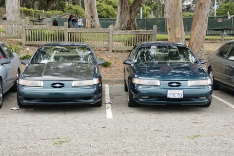 1995 Ford Taurus - Two Ford Taurus sedans are parked next to each other in a lot, with one showing a license plate.