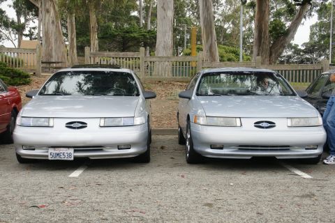 1995 Ford Taurus - Two 1995 Ford Taurus sedans are parked next to each other in an outdoor lot.
