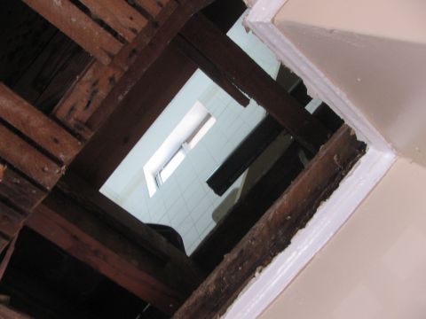 1968 Ford Mustang - Unfinished attic space with exposed wooden beams and a small window.
