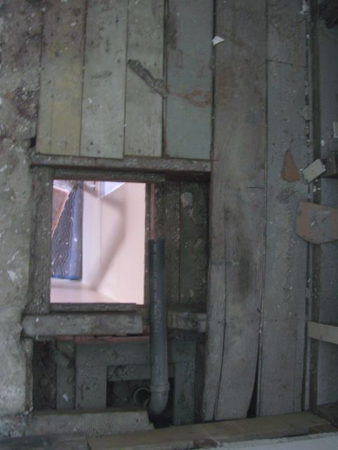 1968 Ford Mustang - A view of an interior wall with exposed pipes and a window, suggesting a construction or renovation site.