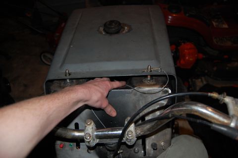 2010 Kawasaki BAYOU 220 - Close-up view of a vehicle's engine compartment with a hand inside.