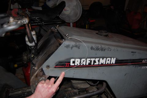 2010 Kawasaki BAYOU 220 - A Craftsman riding mower is shown, with a finger pointing to a loose wire on the body panel.