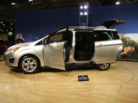 2012 Ford Crown Victoria - A silver minivan is displayed with its doors open, revealing its interior and seating.