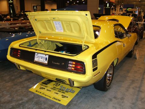 2012 Ford Crown Victoria - A yellow muscle car is shown from the rear with both the hood and trunk open, revealing the interior of the vehicle.