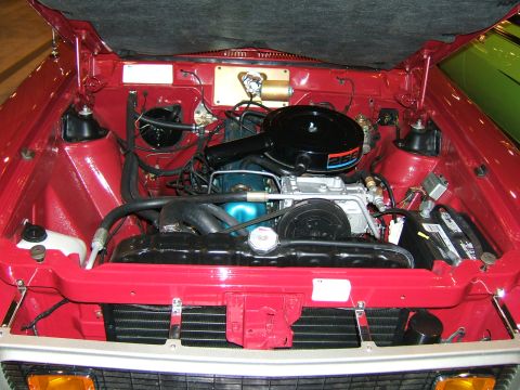 2012 Ford Crown Victoria - The open hood reveals the engine compartment of a red car.