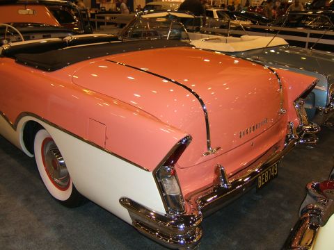 2012 Ford Crown Victoria - A classic two-tone convertible is displayed at an auto show, prominent chrome accents and a vintage license plate.