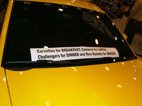 2012 Ford Crown Victoria - A humorous sticker on the windshield of a yellow car lists different car models for various meals.