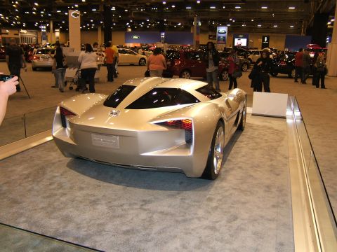 2012 Ford Crown Victoria - A futuristic concept car is displayed at an auto show, viewed from the rear.