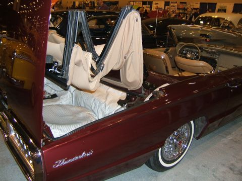 2012 Ford Crown Victoria - Interior view of a maroon convertible, likely a 1956 Ford Thunderbird, with its top mechanism exposed.
