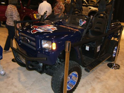2012 Ford Crown Victoria - A blue Ford Dealer golf cart is displayed at an auto show.