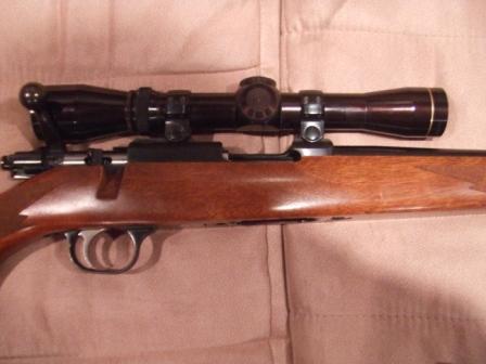 1996 Ford Bronco - A rifle with a scope is shown in detail, resting on a fabric surface.
