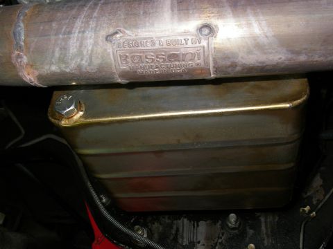 1990 Ford Bronco - A close-up view of a custom exhaust part, showing the manufacturer's stamp and its installation.