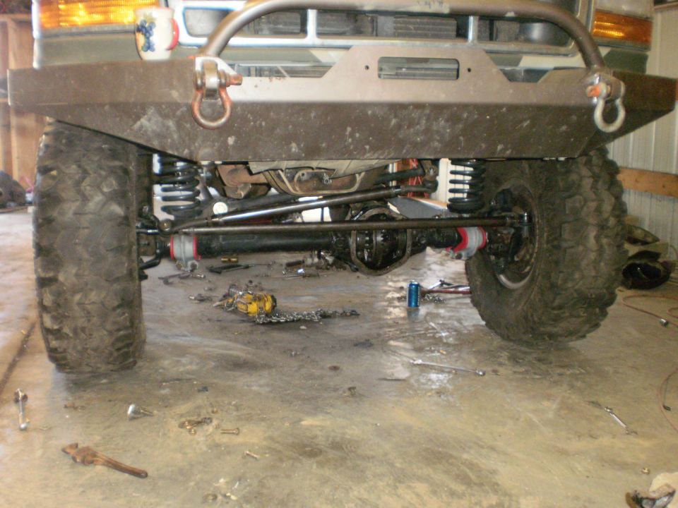 Ford Bronco front axle with aftermarket bumper and suspension components. Tires are large and knobby
