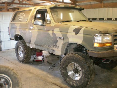 1995 Ford Bronco - This 1995 Ford Bronco, painted in camouflage, is shown on jacks with its suspension lifted.