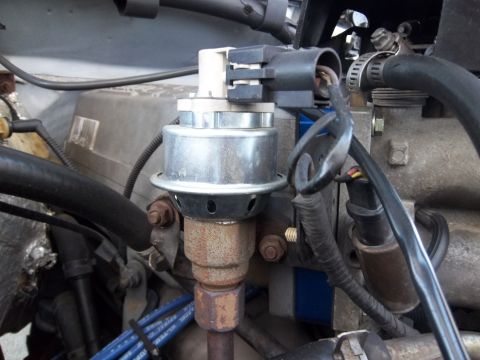 1995 Ford Bronco - A detailed view of an engine part, likely a sensor or actuator, with visible wiring and hoses.