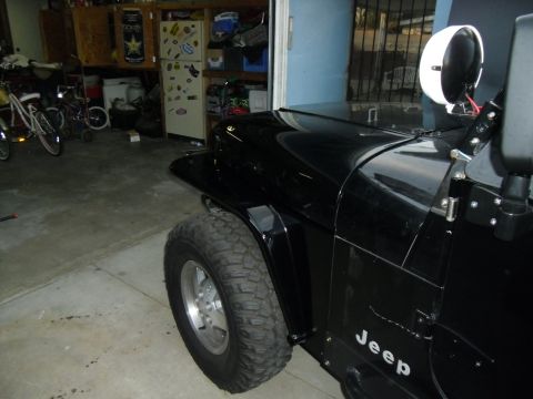 1992 Jeep Wrangler - Side view of a black Jeep Wrangler, its fender and door panel.