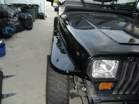 1992 Jeep Wrangler - Front view of a black 1992 Jeep Wrangler, highlighting the fender and hood details.