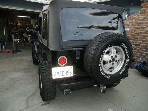 1992 Jeep Wrangler - This Jeep Wrangler is parked in a garage with tools and bicycles visible in the background.