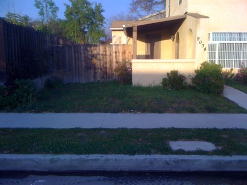 1968 Ford Mustang - Exterior view of a house with address 9034, a sidewalk and a wooden fence.