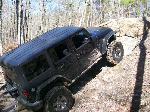 2007 Jeep Wrangler - A black 2007 Jeep Wrangler navigates a challenging off-road trail.