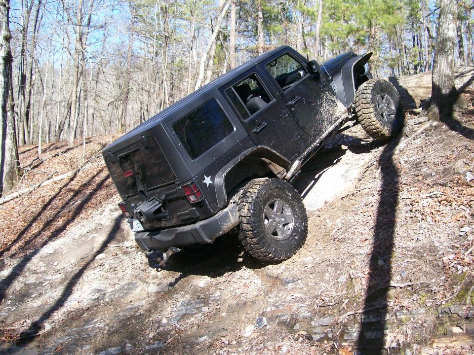 Black Jeep Wrangler climbing a rocky, wooded trail. It's a 2007 model